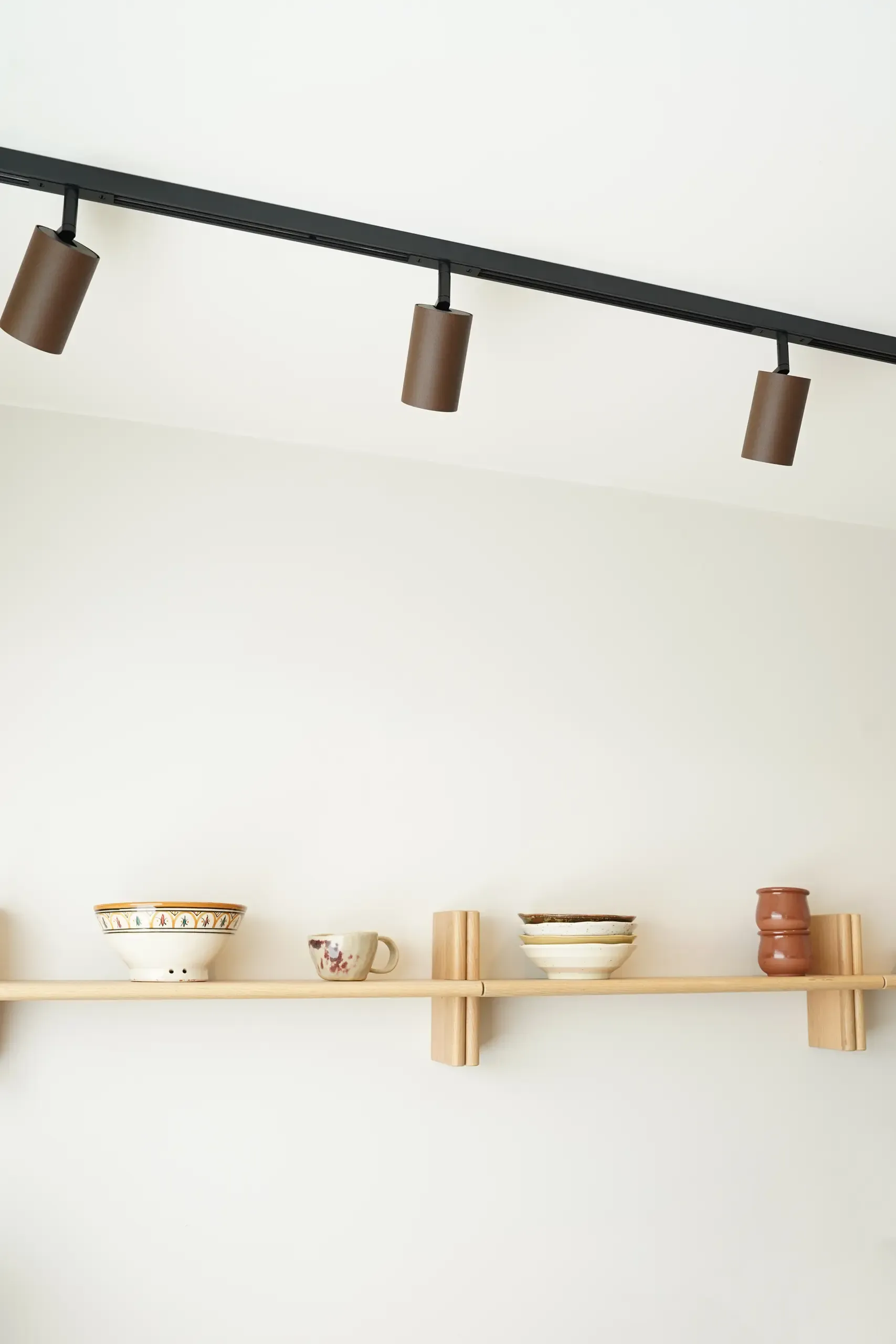Designline Schiene mit Tube Pro Spots in Rost über einem Regal