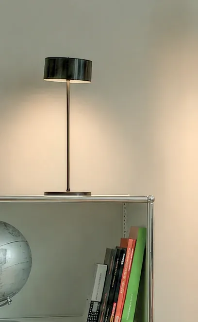 Tischleuchte Fly Glas in Schwarz auf einem weißen Sideboard
